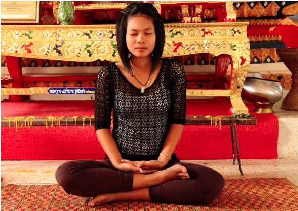 Image of a person sitting cross legged and meditating.