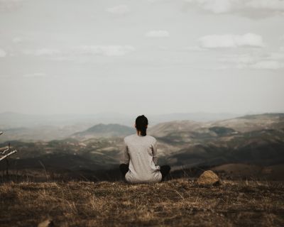 Woman sitting with her back to the camera on a mountain