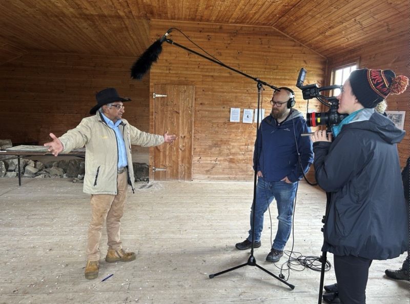 Gunditjmara Elder Uncle Johnny Lovett in conversation with two people who are chatting with him while they record the conversation.
