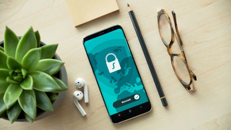 Image of a mobile phone, pot plant and pair of glasses