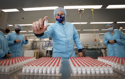 Prime Minister Scott Morrison holds a COVID-19 vaccine in his hand 