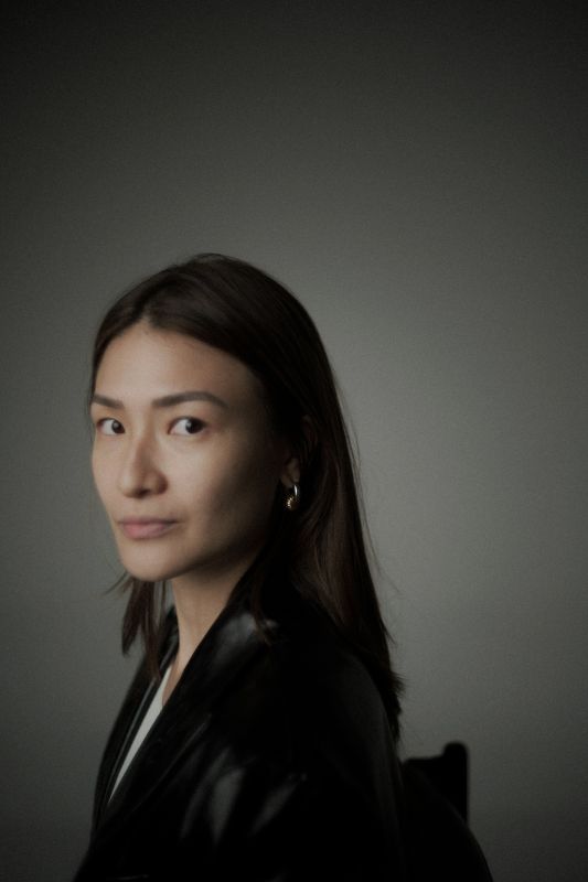 Dark haired woman wearing a dark suit looking side on
