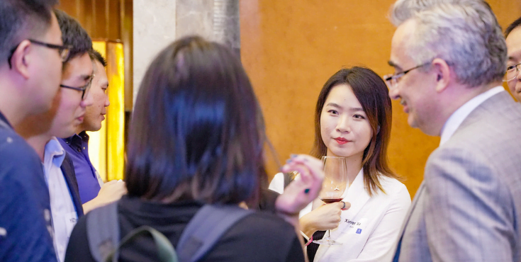 A group of seven alumni in conversation at a Shanghai Alumni Association event.
