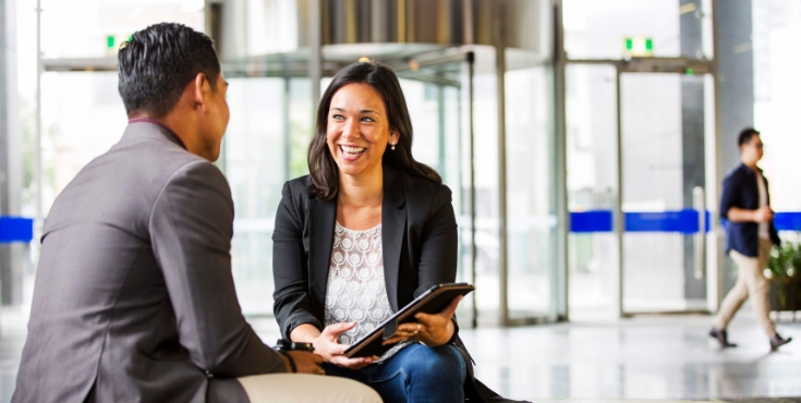 A man and woman discussing tax deductible doantions in a professional office environment.
