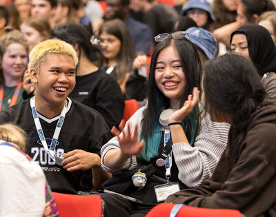 Students chatting excitedly at an event.