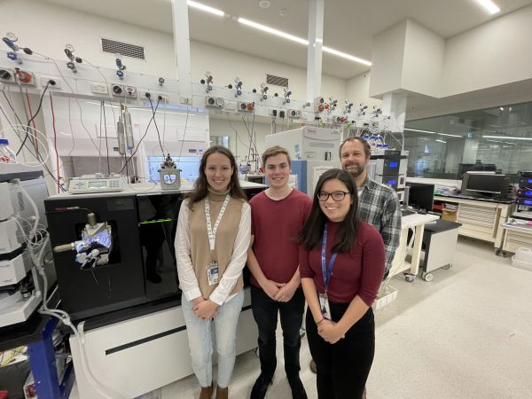 Four people standing together in a lab