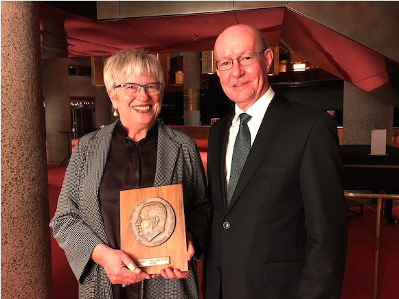 Image of Mary Vallentine AO holding the award with Professor Gary McPherson.