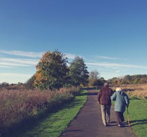 Two elderly people walking in the park