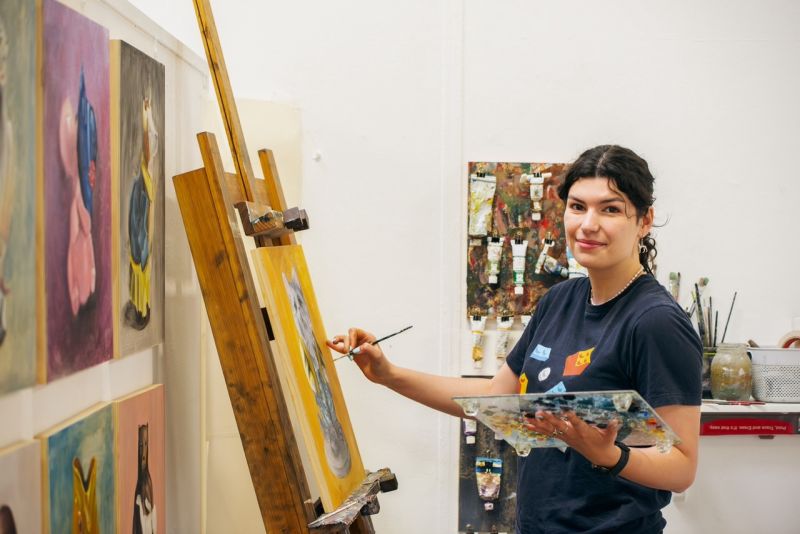 Student Grace Murphy paints in her studio