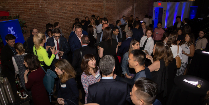 A large group of alumni mingling at a New York Alumni Association event.