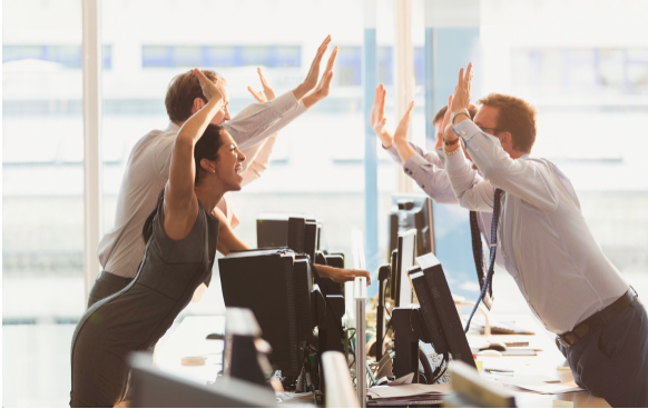 Image of colleagues giving each other high-fives in an office.