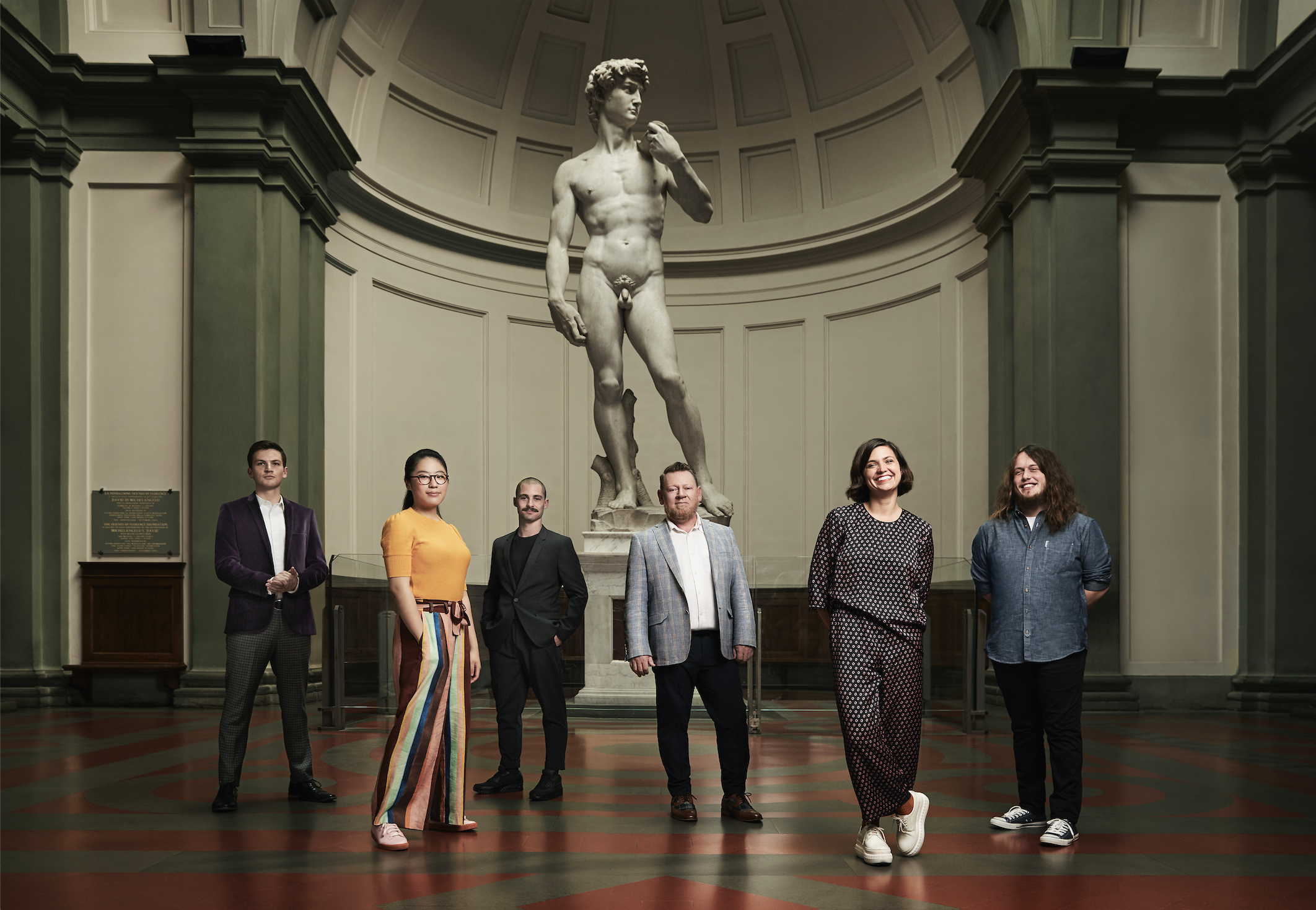 Five people stand in front of Michelangelo's David
