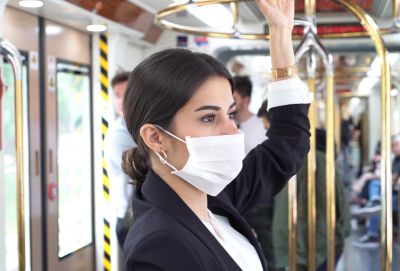 Image of a woman in a tram wearing a mask.