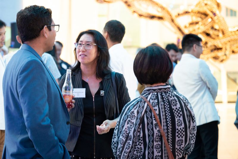 Dental alum Patsandra Lam (centre) talking with fellow alumni.