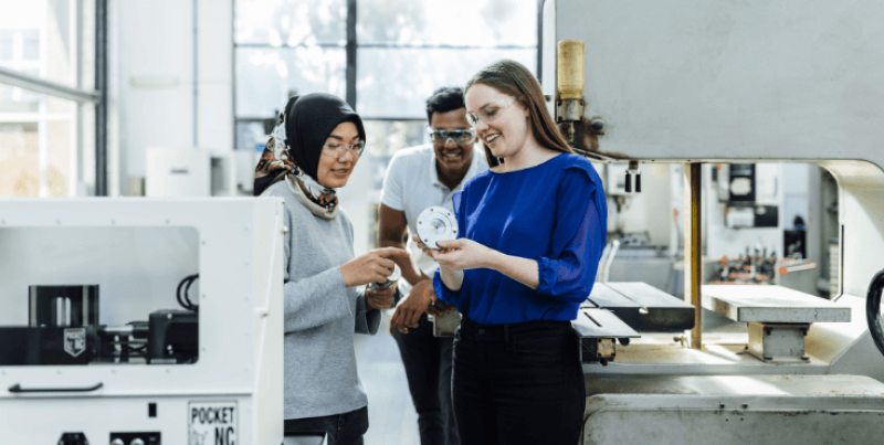 A group of students and researchers working together in an engineering lab.