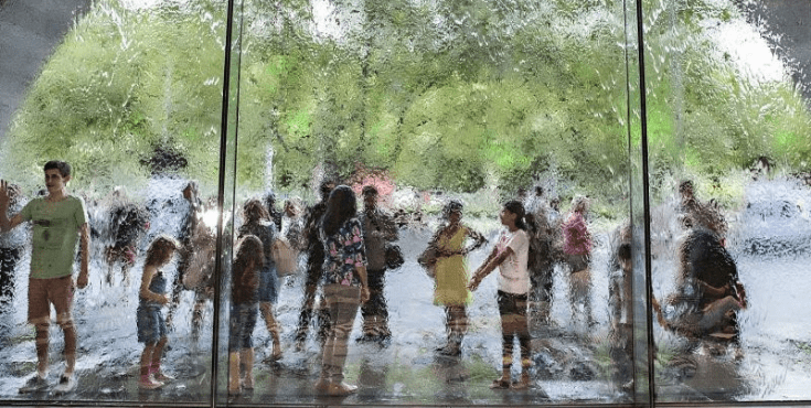 A group of NGV gallery visitors pictured through the wall of water at the entryway.