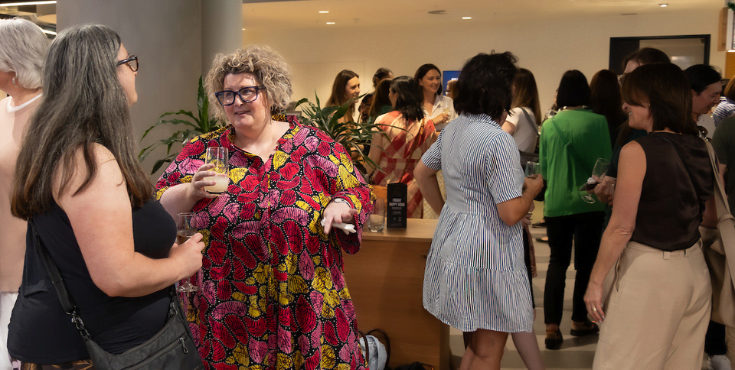 An alumni volunteer conversing with other alumni at a group event.