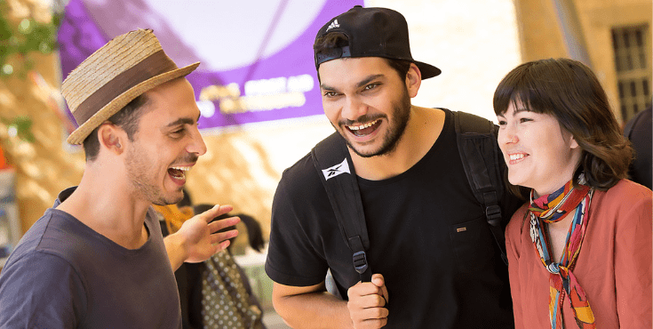 Three individuals laughing and having a conversation.