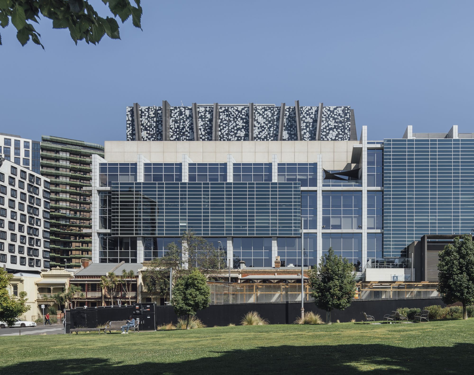 Modern glass building (Faculty of Business and Economics) viewed from an open grassy area