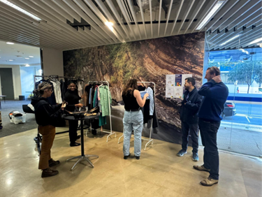 Students browsing clothing at an indoor pop‑up display