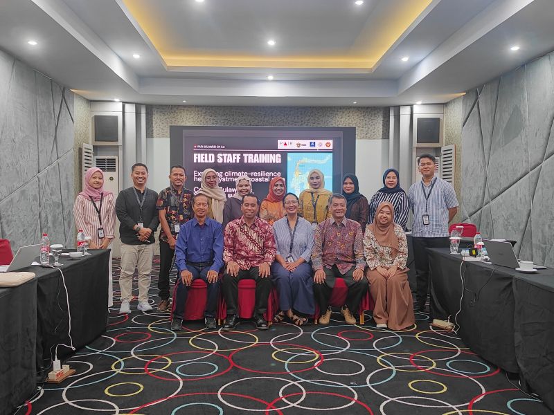 Group of people posing for a photo inside a conference room,