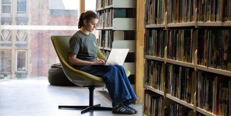 Student studying in the library on her laptop