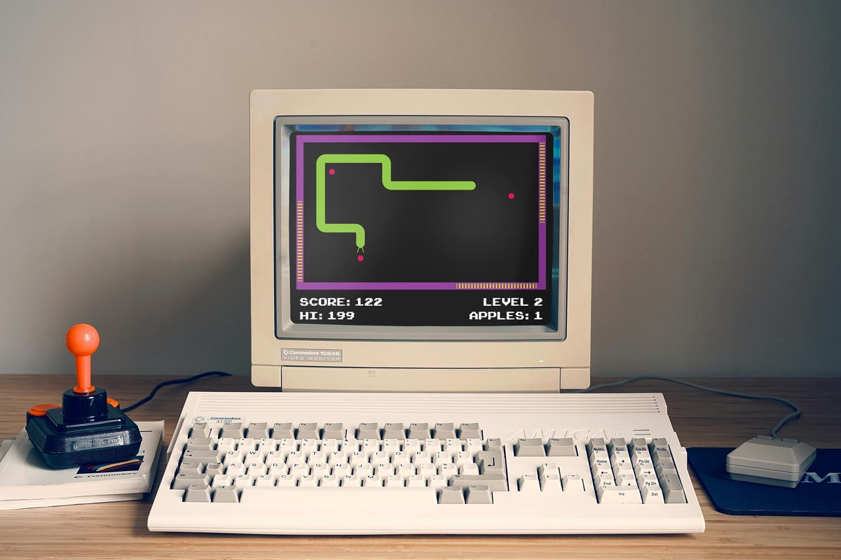 A photo of an old retro computer with a game of snake on screen