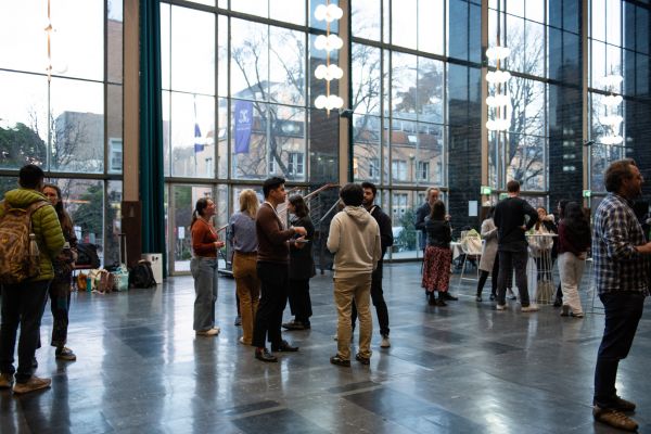 Groups of students standing in a large hall.