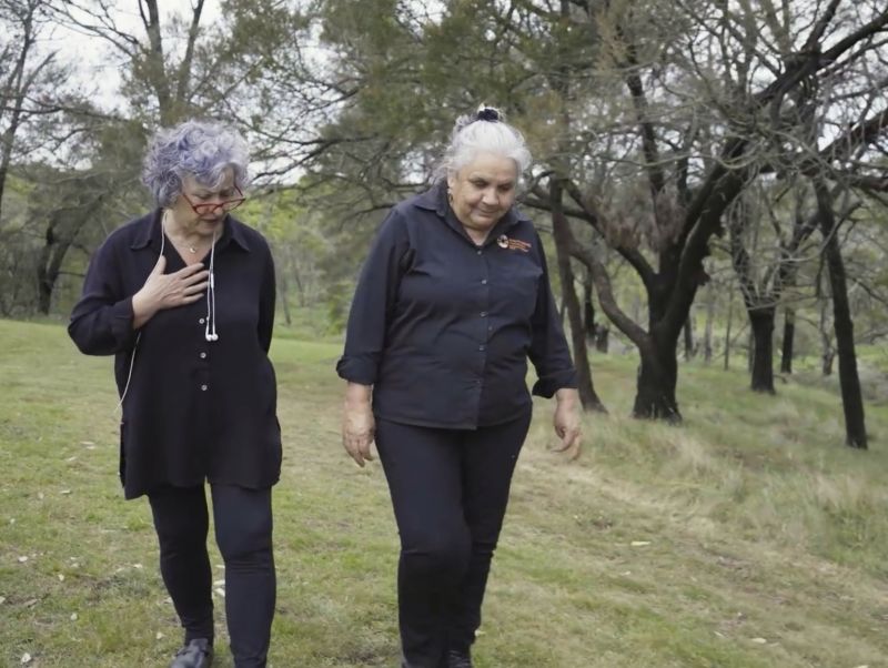 Two women wearing black walk and talk on Country at Budj Bim Cultural Landscape.