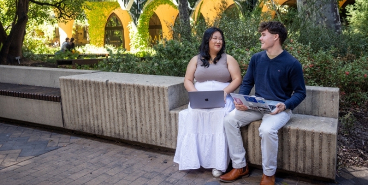 Two students sitting and discussing on ways to donate to the university.