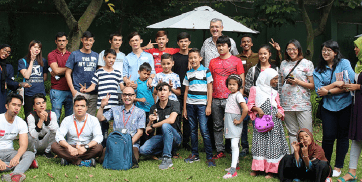 A large group of Indonesian alumni posing for a picture together on some lawn.