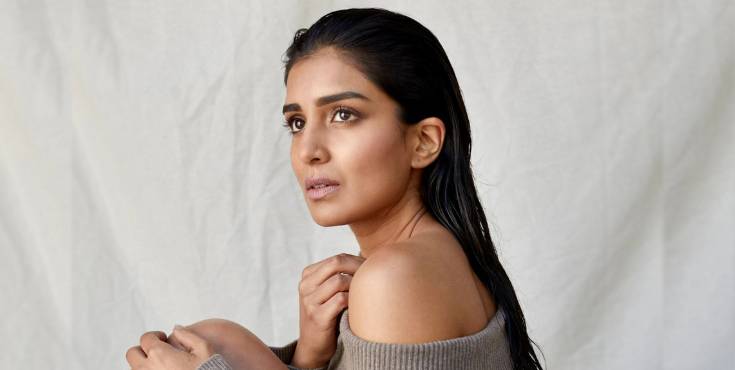 Pallavi Sharda gazing into the distance against a grey studio background.