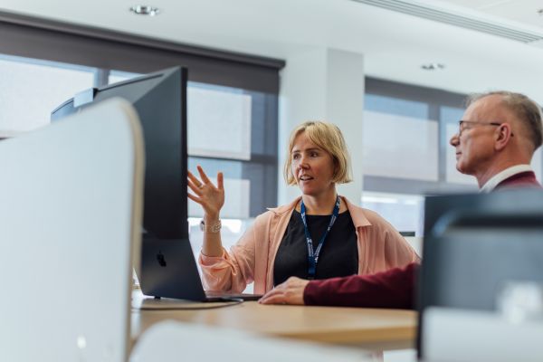 Woman talking to man at standing desk