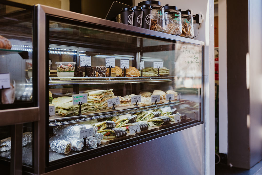 A display case filled with various sandwiches and lunch items
