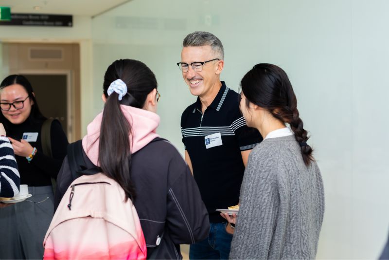 Chris Crellin with talking with University students at a Fireside Chat in October 2024.