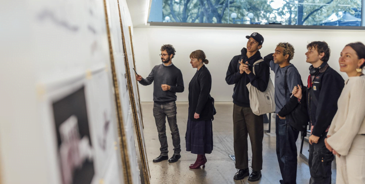 A group of alumni viewing artworks at an on-campus gallery.