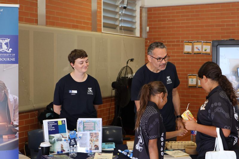 Two adults and two children at a stall.