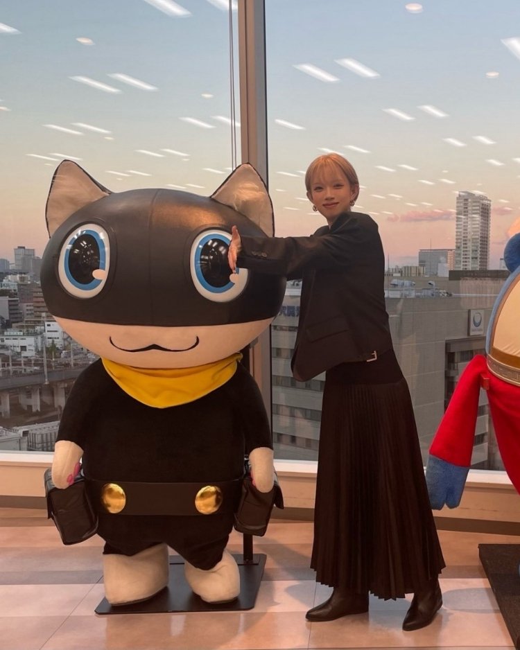 Woman standing next to an Anime character