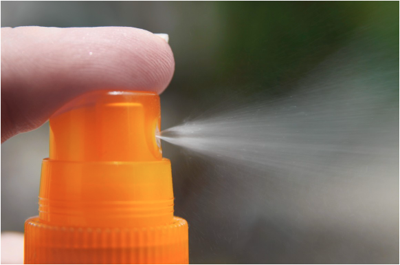 Close-up image of an atomiser spraying liquid.