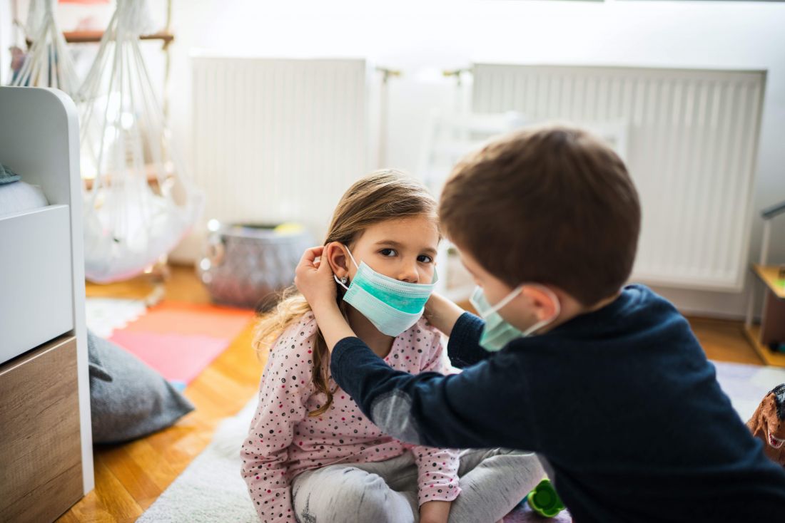 Preschoolers putting face masks on each other