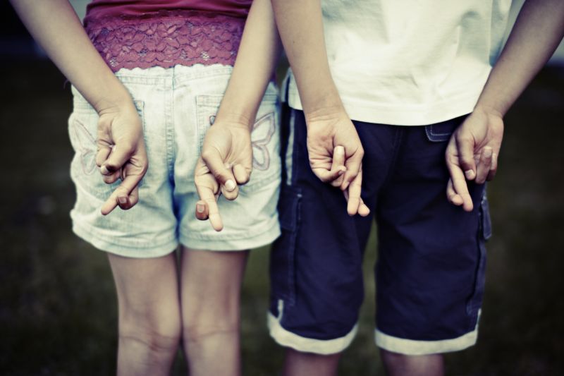 Two children with their fingers crossed behind their backs