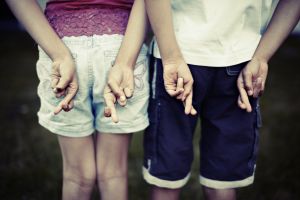 Two children with their fingers crossed behind their backs