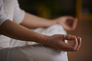 Image of person sitting down with hands rested on their knees in yoga posa