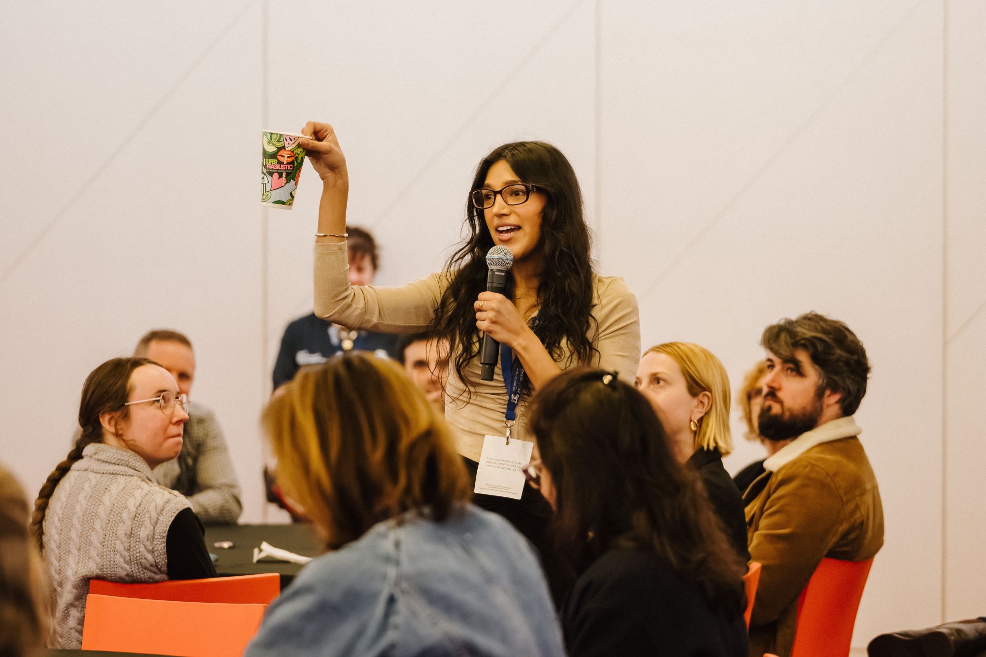 Staff member conducting Sustainable Waste session to staff and holding decorative cup
