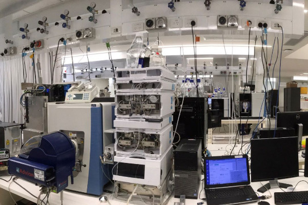 Three people standing in a lab in conversation.