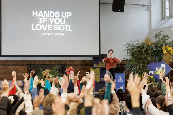 Alex Wood presenting at Wattle Spotlight event and having the audience raise their hands. Image by James Thomas Photography (2025).