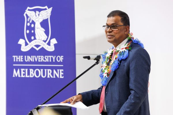 A male speaker standing at a lectern addressing an audience