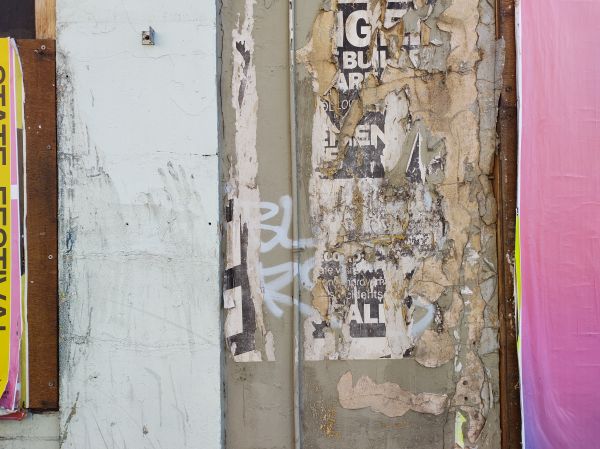 Image of a Street wall with a poster tatered