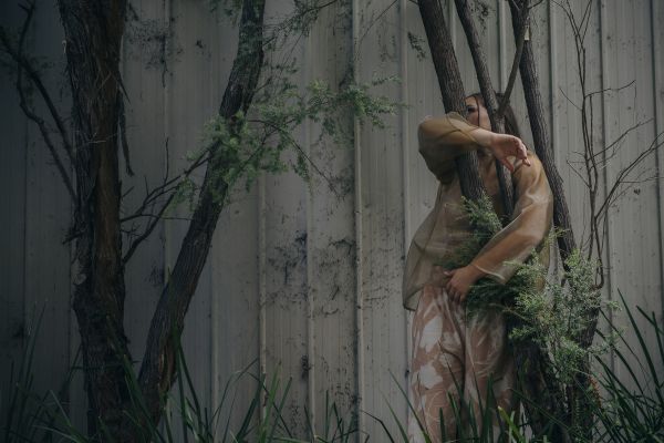 One woman dancer amid a tree and leaf background