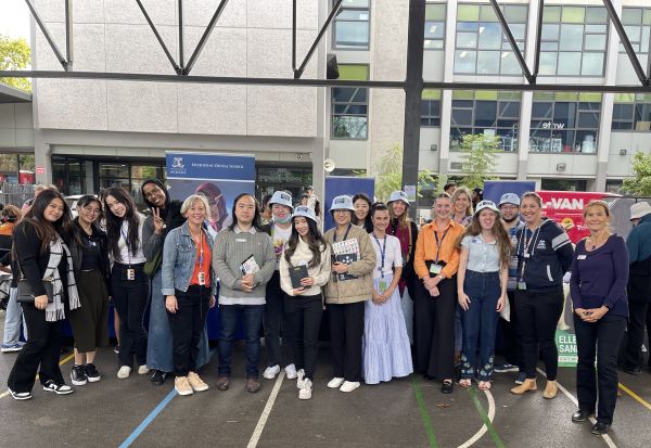 A group of about 20 students and staff smiling at the Carlton Harmony Day